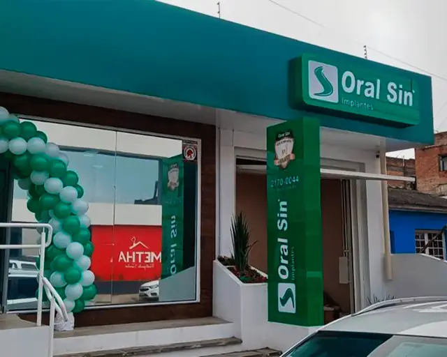 Fachada da clínica Oral Sin com totem vertical e letreiro em ACM verde
